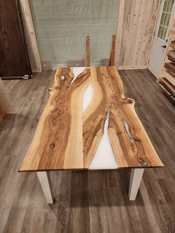 front view of english walnut wood dining table with bookmatched slabs and white epoxy