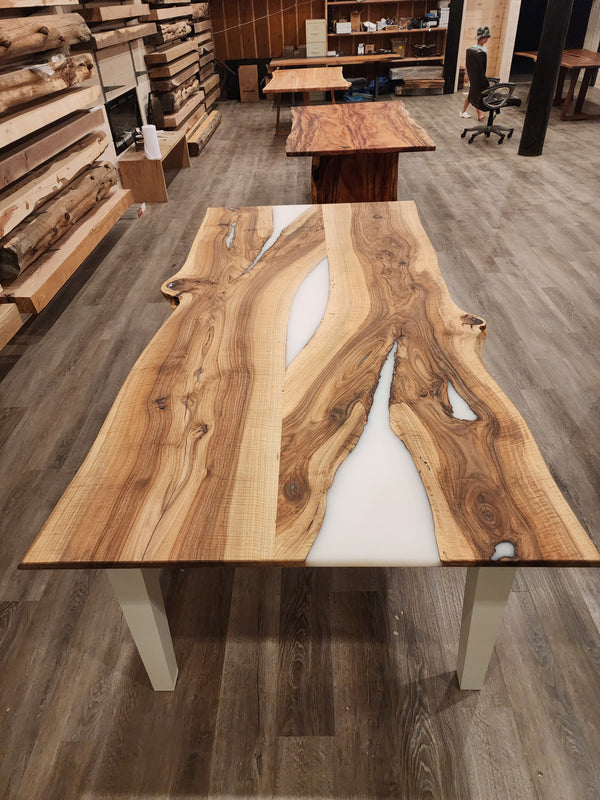 front view of english walnut wood dining table with bookmatched slabs and white epoxy