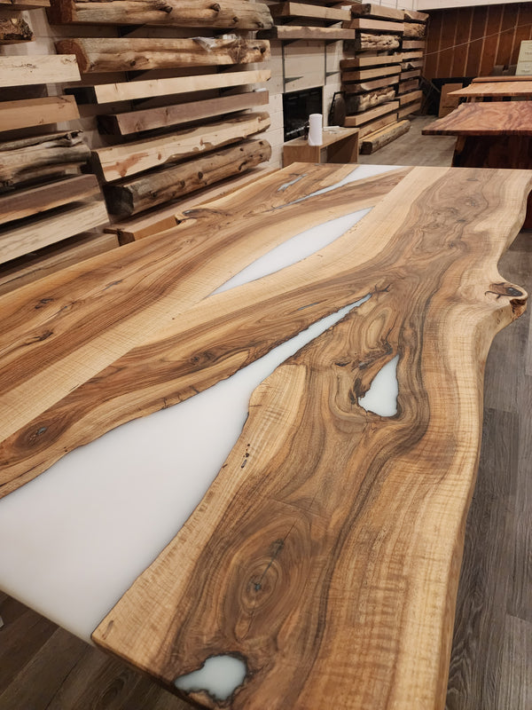 front view of english walnut wood dining table with bookmatched slabs and white epoxy