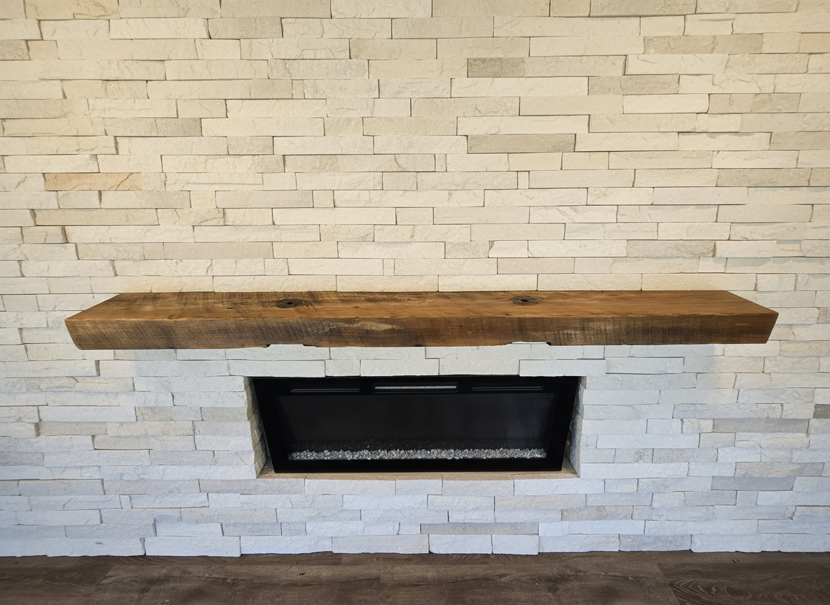 Wooden mantel over an electric fireplace with wooden wall and floor.
