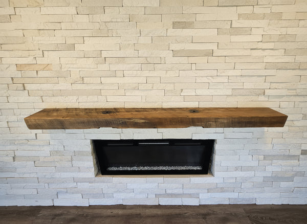 Wooden mantel over an electric fireplace with wooden wall and floor.