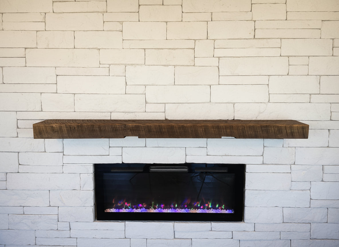 Wooden mantel above a built-in electric fireplace with decorative lights against a wooden wall.