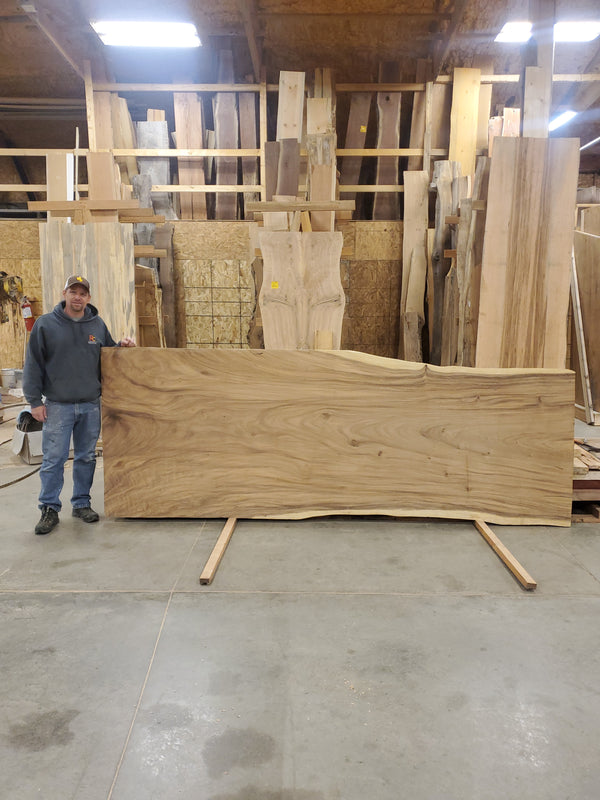 Man standing next to large wood slab