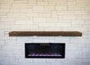 Wooden mantel above a built-in electric fireplace with decorative lights against a wooden wall.